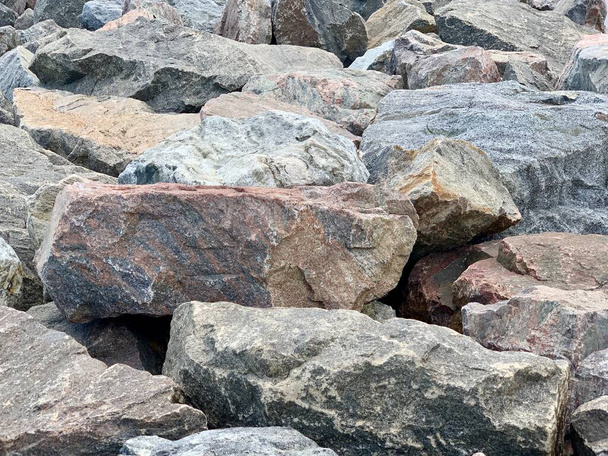 Achtergrondtextuur: veel grote stenen van verschillende vormen. Een stapel granieten rotsblokken. Concept - steen, hardheid, solide fundering - Foto, afbeelding