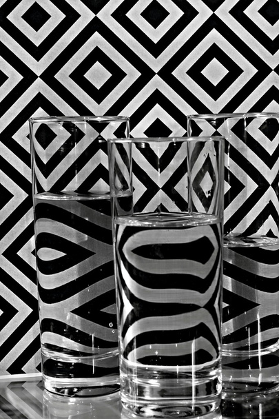 Óculos com água e ornamentos geométricos sobre fundo
 - Foto, Imagem