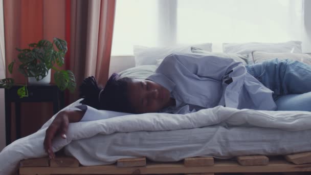 mooie jong Afrikaans amerikaans vrouw wakker in bed en kijken naar de camera - Video