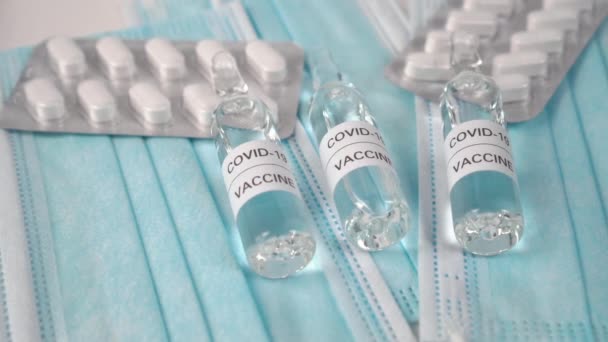 Set von Medikamenten gegen Coronavirus. COVID-19 Impfstoff mit weißen Pillen auf blauen medizinischen Masken. Virenprävention und Behandlungskonzept - Filmmaterial, Video