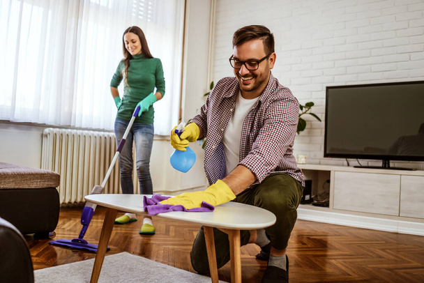 Junges glückliches Paar putzt seine Wohnung. - Foto, Bild