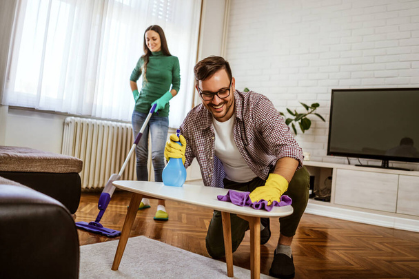 Young happy couple is cleaning their apartment. - Фото, зображення