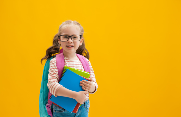 Back to school and happy time! Cute industrious child on color paper wall background. Kid with backpack. Girl ready to study. - Fotografie, Obrázek