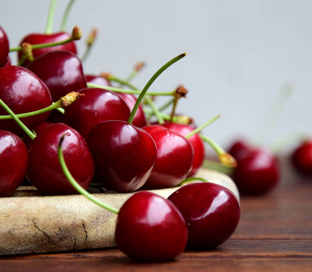 Вкусные красные вишни на деревянном фоне - Фото, изображение