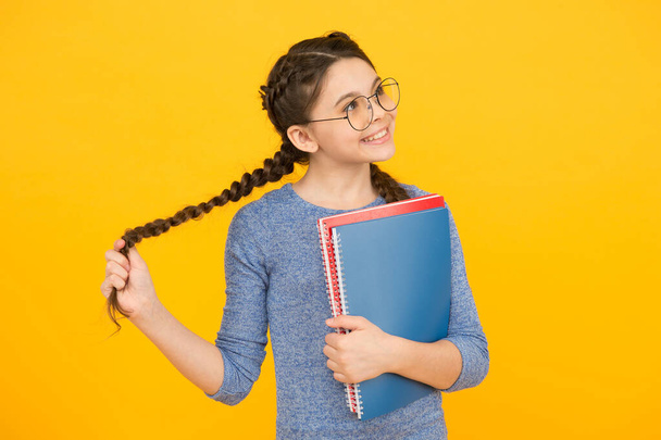 Flights of imagination. Girl with long plaits hold books. Little dreamer with thoughtful look yellow background. Imagination and fantasy. Developing imagination. Learning with imaginaiton matters - Foto, Imagem