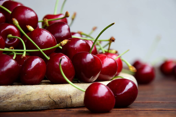 Delicious red cherries on a wooden background - Fotografie, Obrázek