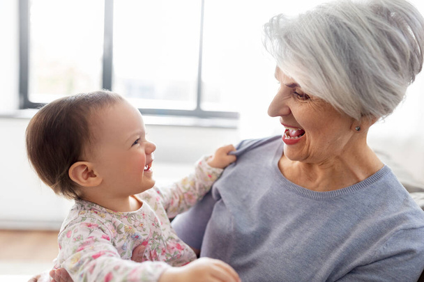 happy grandmother with baby granddaughter at home - Фото, зображення