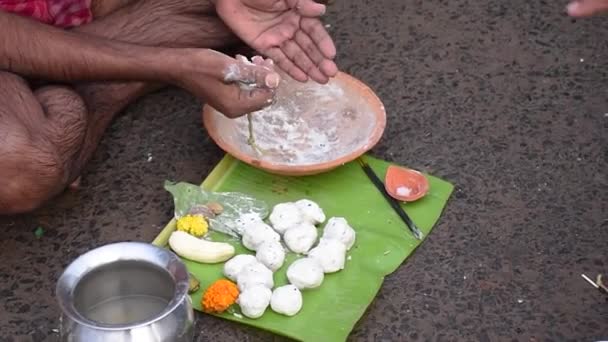 Indiase hindoe mensen bieden trouw "Tarpan" aan het goddelijke voor de bevrijding van de ziel van hun overleden ouderen in Mahalaya Paksha en Sola Shraddha.  - Video