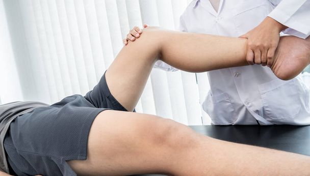 男性患者は診察と治療のために膝痛の問題を理学療法士に相談した。リハビリテーション理学療法の概念. - 写真・画像
