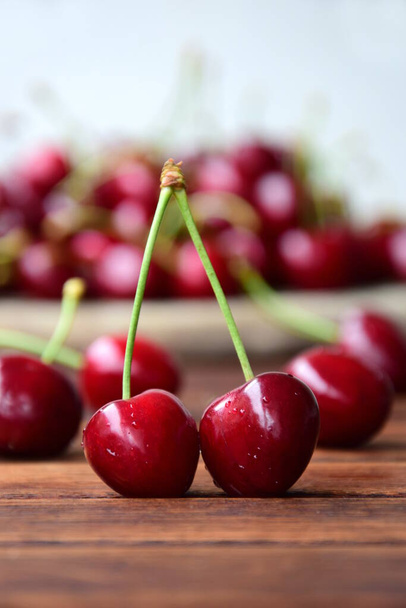 Delicious red cherries on a wooden background - Foto, afbeelding