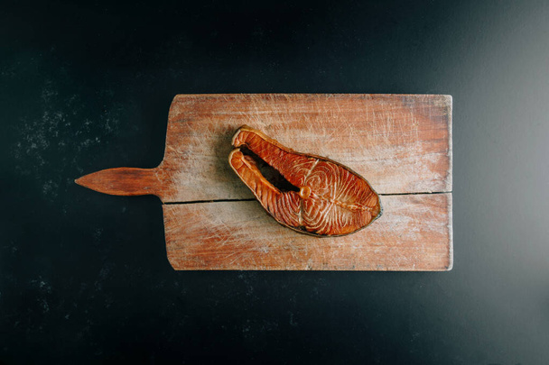 Кусочек копченого лосося на винтажной доске - Фото, изображение