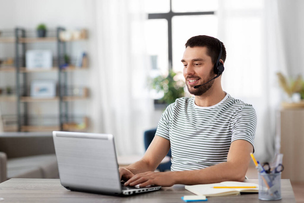 man with headset and laptop working at home - Photo, image