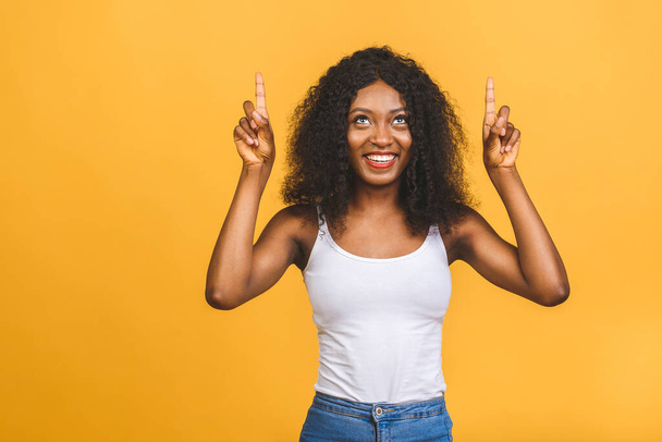 幸せな若いアフリカ系アメリカ人女性の肖像画指を離れてコピースペースで黄色の背景に隔離. - 写真・画像