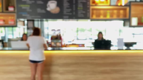 Abstracte wazig beeldmateriaal mensen in coffeeshop interieur met heldere verlichting in cafe bar. 4K Wazig achtergrond van cafe restaurant, eetkamer of coffeeshop met bokeh licht abstract.  - Video