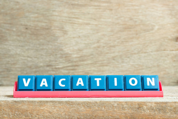 Lettera di piastrelle su rack rosso in vacanza parola su sfondo di legno - Foto, immagini