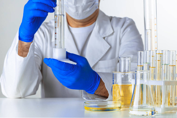 Scientist hands holding some liquid in a glassware in laboratory for analysis - Foto, immagini