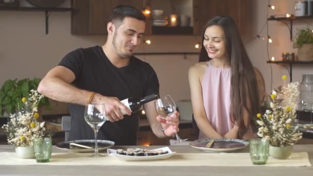 Rindo jovem casal gostando de passar o tempo juntos bebendo vinho tinto
. - Filmagem, Vídeo