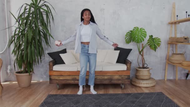 Happy young black woman with headphones dancing at room. - Video, Çekim