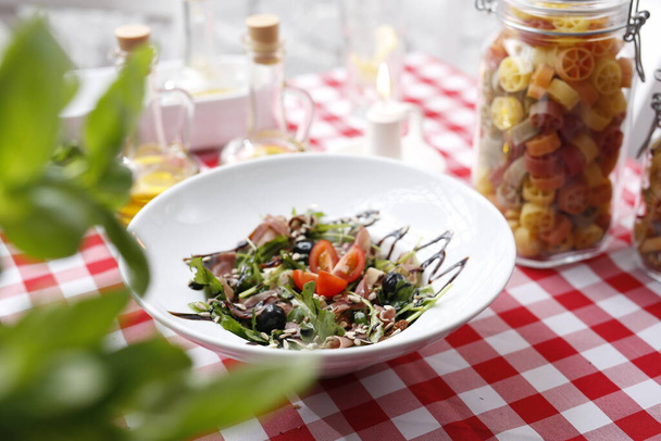 Salade met Parmaham, tomaten en balsamico saus. - Foto, afbeelding
