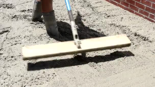 Trabajador de la construcción vierte cemento para acera en obras de hormigón con carretilla
 - Metraje, vídeo