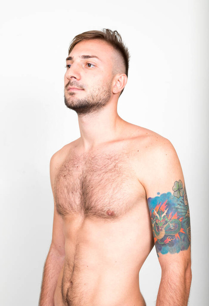 Studio shot of bearded man with blond hair shirtless against white background - Foto, immagini