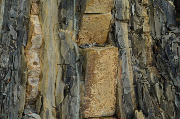 Las capas de roca - las formaciones coloridas de las rocas echadas a lo largo de los centenares de años. Fondo interesante con textura fascinante
. - Foto, Imagen