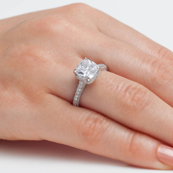 navlékání šperky na ženské prst leštěné ruce na bílém pozadí - Fotografie, Obrázek