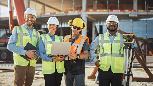 Diverse Team of Specialists Use Laptop Computer on Construction Site. Real Estate Building Project with Machinery: Civil Engineer, Investor, Businesswoman and Builder Discussing Blueprint Plan - Foto, Imagen