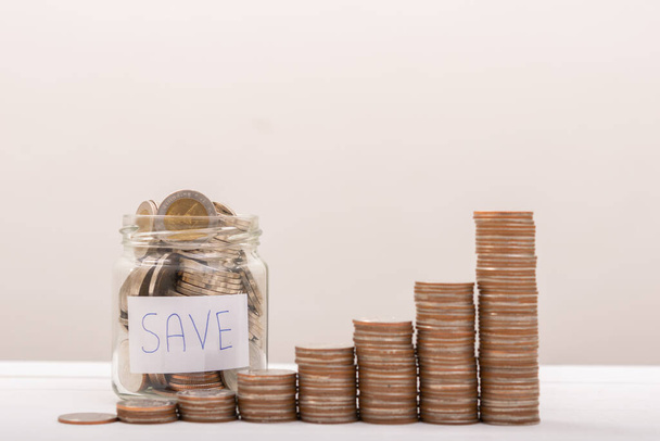 Jar with money stack step growing growth saving money with gray background - Valokuva, kuva