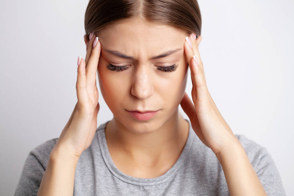 Una mujer joven tiene un fuerte dolor de cabeza
 - Foto, Imagen