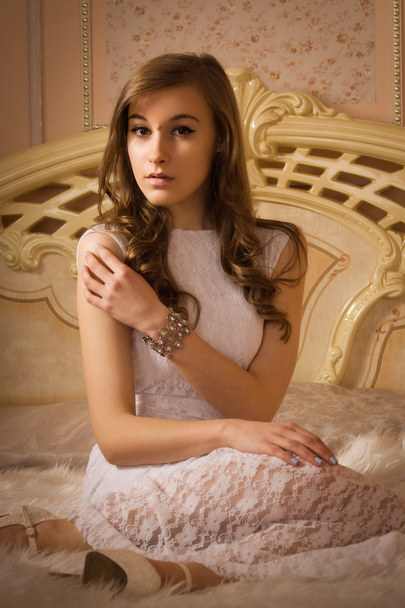 Elegant girl in evening dress in an elegant bedroom - Foto, Imagen