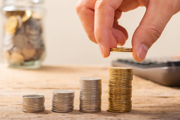 Hand Münzen auf den Tisch legen, Sparkonzept oder Geschäftswachstumskonzept - Foto, Bild