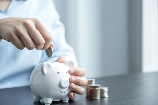 Woman putting coin into piggy bank, step up start up business to success, Saving money for future plan and retirement fund concept. - Photo, Image
