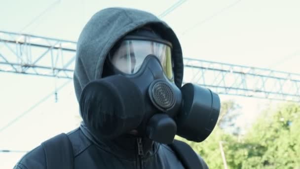 Człowiek w masce przeciwgazowej na epidemii na świeżym powietrzu. broń chemiczna, ochrona przed wirusami - Materiał filmowy, wideo