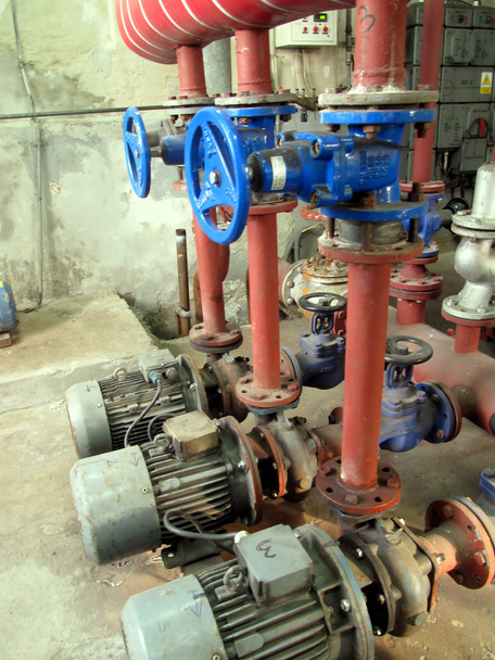 válvulas com cabos azuis e bombas antigas embutidas na instalação
 - Foto, Imagem