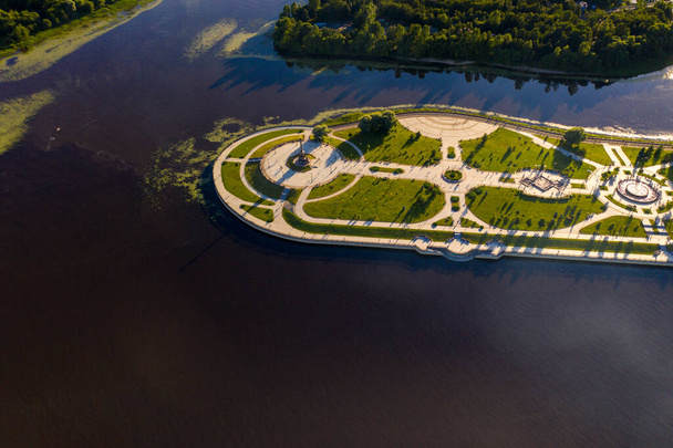 een amusements- en recreatiepark met fonteinen op een schiereiland naast een grote rivier gefilmd vanaf een drone - Foto, afbeelding