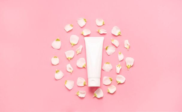Delicate skin care cosmetic feminine flatlay. Top view Creative composition of face cream ,glass bottles and jars with cosmetic and flowers leaves - Photo, Image