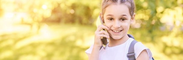 Cute little girl talking. Hold phone near face - Фото, изображение
