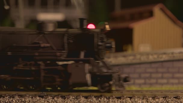 Sluiten van speelgoed locomotief met wagons bewegen op de spoorweg. - Video