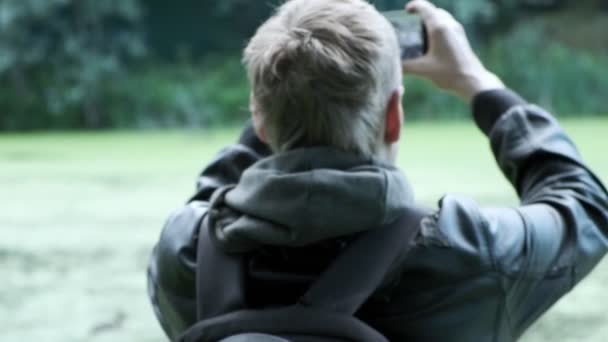 男はスマホでアヒルの写真を撮る。野生の鳥の写真を撮り - 映像、動画