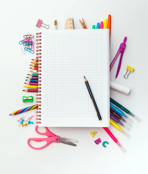 Photo of office and student gear over white background - Back to school concept. Blank squared notebook on school supplies - Φωτογραφία, εικόνα