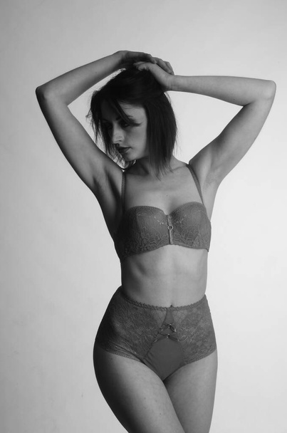 beautiful woman with short hear in lingerie posing on light studio background    - Фото, зображення