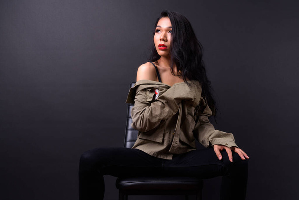 Studio shot of young beautiful Asian transgender woman against black background - Photo, Image