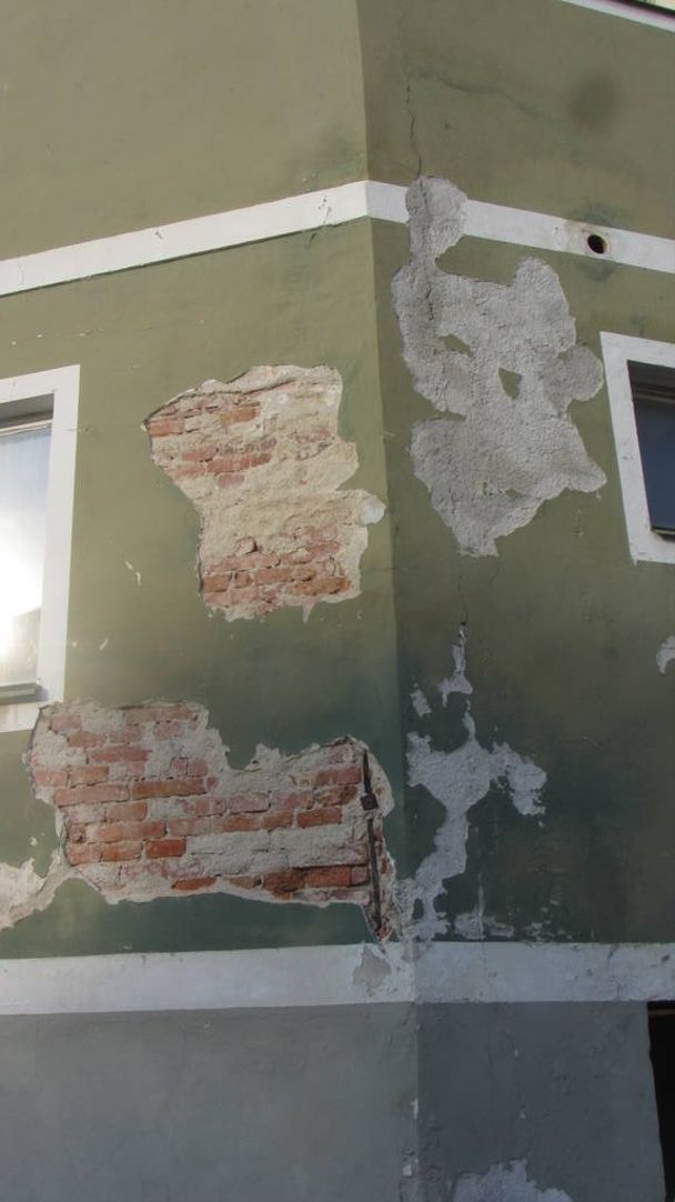 структурні пошкодження будинку зеленим фасадом, розсипається штукатурка
 - Фото, зображення
