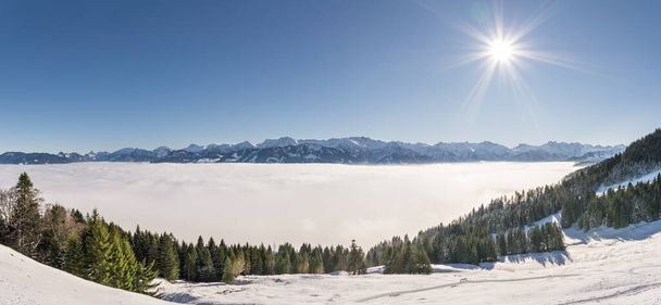 Fantastique vue panoramique sur les montagnes de neige avec ciel bleu et soleil. Grand panorama sur la chaîne de montagnes au-dessus de la couche de brouillard vallée d'inversion. Ofterschwanger Horn, Alpes, Allgau, Bavière, Allemagne. - Photo, image