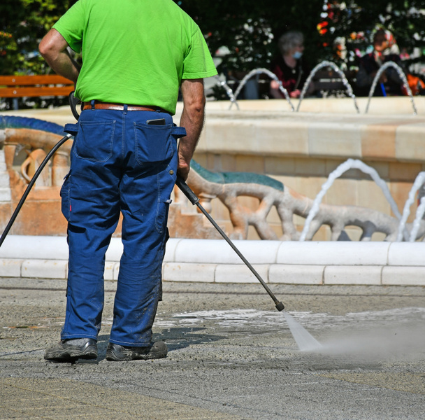 Dělník čistí ulici horkou vodou. - Fotografie, Obrázek