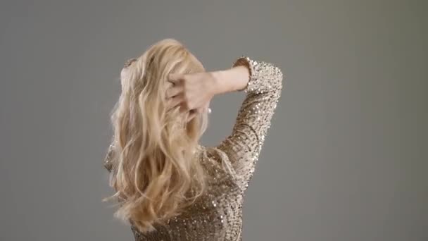 Gyönyörű fiatal nő göndör haj szürke háttér - Felvétel, videó