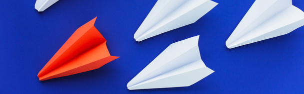 vue de dessus des avions en papier blanc et rouge sur fond bleu, concept de leadership, prise de vue panoramique - Photo, image