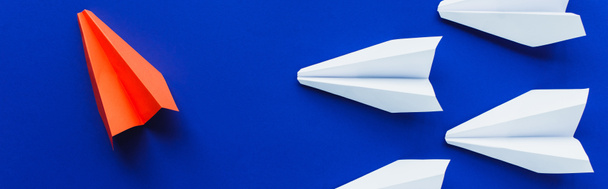 vista superior de planos de papel blanco y rojo sobre fondo azul, concepto de liderazgo, plano panorámico - Foto, Imagen