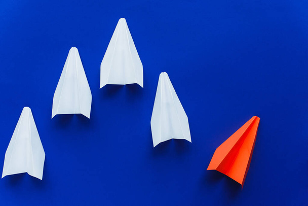 top view of white and red paper planes on blue background, leadership concept  - Valokuva, kuva